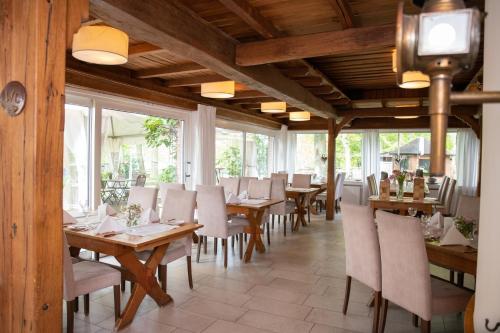 a restaurant with wooden tables and chairs and windows at Hotel Restaurant Große Teichsmühle in Dülmen