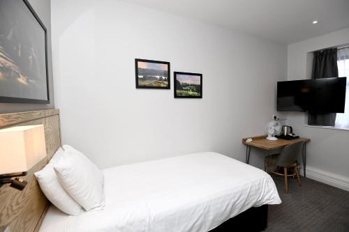a hotel room with a bed and a desk at Fox & Goose, Barrow Gurney by Marston's Inns in Bristol