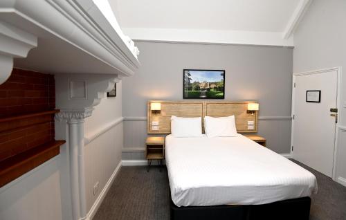 Schlafzimmer mit einem Bett mit weißer Bettwäsche in der Unterkunft Fox & Goose, Barrow Gurney by Marston's Inns in Bristol