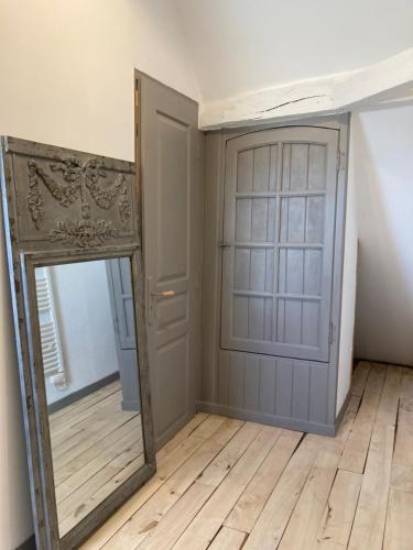 a mirror and a door in a room at Le Murmure des Fées in Issigeac