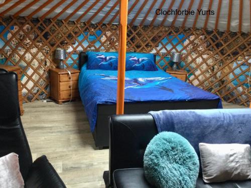 um quarto com uma cama e uma cadeira numa tenda em Colourful Mongolian Yurt enjoy a new experience em Turriff