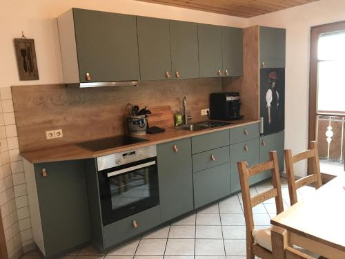 eine Küche mit grünen Schränken, einer Spüle und einem Herd in der Unterkunft Morgethof in Wolfach