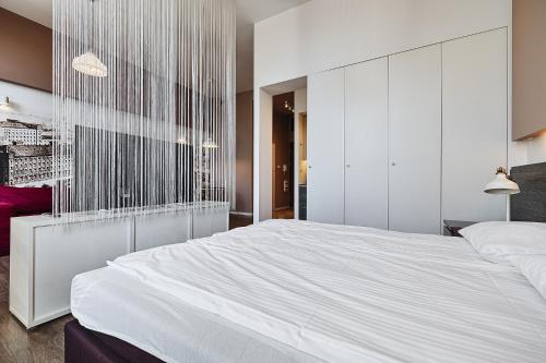 a bedroom with a large white bed with a wall at Loft Glamour by LookAp in Łódź
