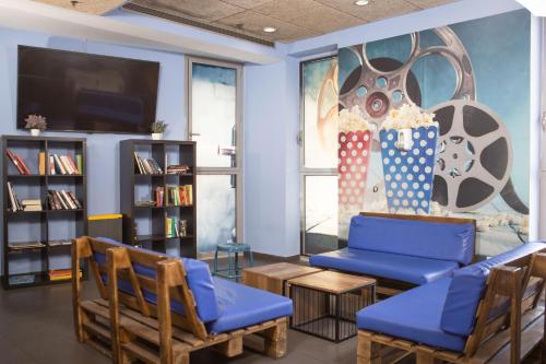 a waiting room with blue chairs and a tv at Urbany Hostel Barcelona in Barcelona