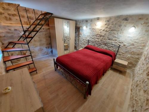 a bedroom with a red bed and a staircase at Elgina Apartments2 MANI in Mína