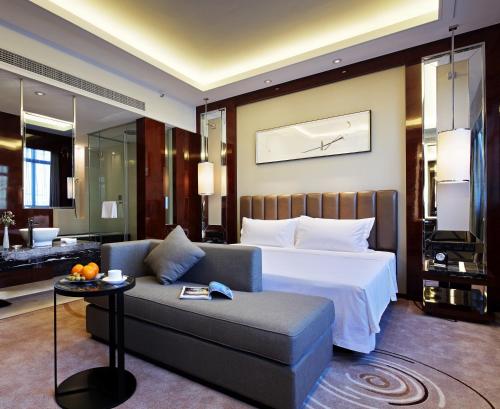 a hotel room with a bed and a couch at Ramada Changzhou North Hotel in Changzhou