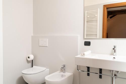a white bathroom with a toilet and a sink at Gustificio in Carmignano di Brenta