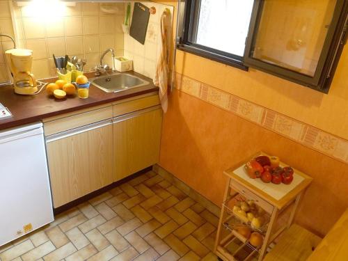 - une cuisine avec un évier et une table avec des fruits dans l'établissement Studio confortable pour 2 personnes avec balcon, au centre de Luchon, proche télécabine et thermes - FR-1-313-120, à Luchon