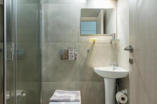 ein Bad mit einer Dusche und einem Waschbecken in der Unterkunft Nereid Apartment in Athen