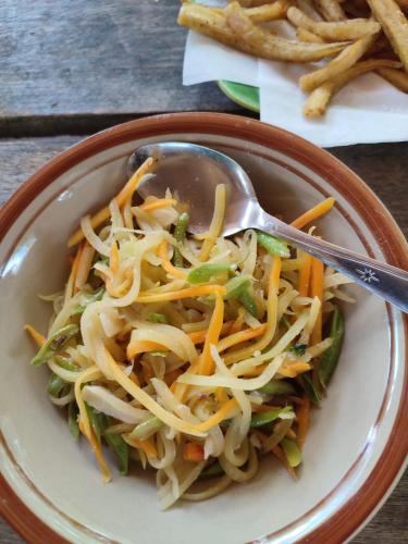 a bowl of food with a spoon in it at Sunset Homestay by Harry & Mimin in Telaga
