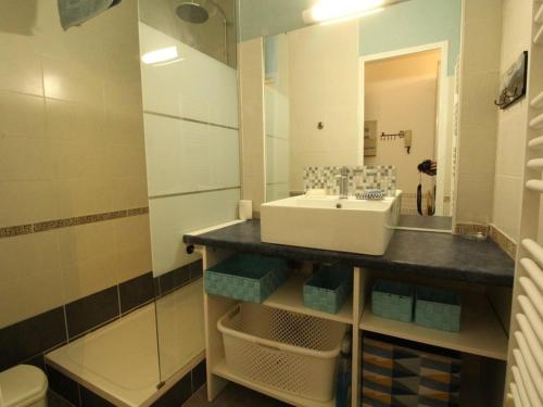 une salle de bain avec un lavabo et un miroir dans l'établissement Charmant T2 avec balcon, parking privé, au pied du télécabine - Bagnères-de-Luchon - FR-1-313-198, à Luchon