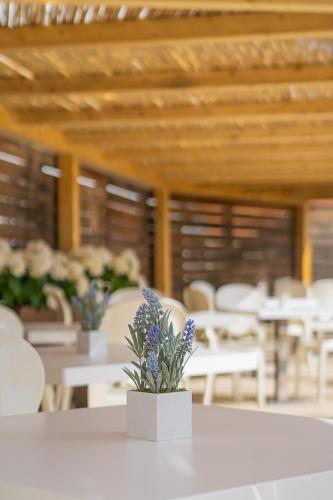 a white table with purple flowers on top of it at Mercure Olbia in Olbia