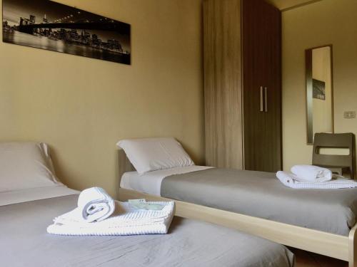 two beds with towels on them in a room at Poncinvs Residence in Bergamo