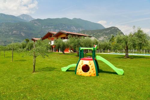 a playground with a slide in a field of grass at Agriturismo Maso Bergot in Arco