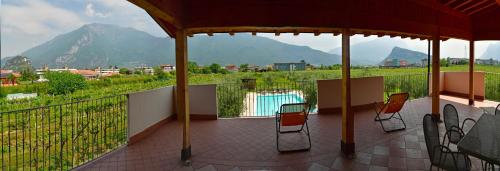 a balcony with chairs and a pool and mountains at Agriturismo Maso Bergot in Arco