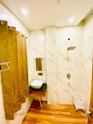 a bathroom with a sink and a shower and a toilet at Avista Hotel in Amritsar