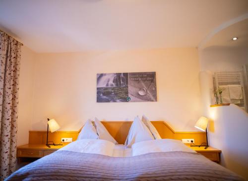 ein Schlafzimmer mit einem Bett mit weißen Kissen in der Unterkunft Gasthof Abfalter in Golling an der Salzach