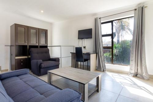 a living room with a couch and a table at Linden Guest House in Johannesburg