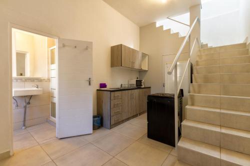 una cocina con escalera y lavabo en Linden Guest House, en Johannesburgo