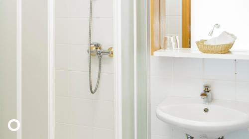 a white bathroom with a shower and a sink at Center Hotels Skjaldbreid in Reykjavík