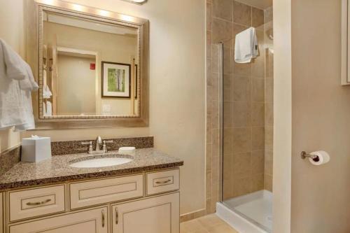 韋爾的住宿－Aspen at Streamside at Vail，浴室配有盥洗盆和带镜子的淋浴