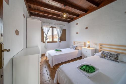 a bedroom with two beds and a window at Villa Alisios La Asomada in Tías