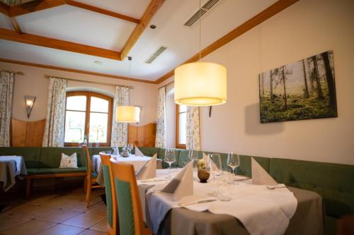 uma sala de jantar com mesas, cadeiras e janelas em Gasthof Abfalter em Golling an der Salzach