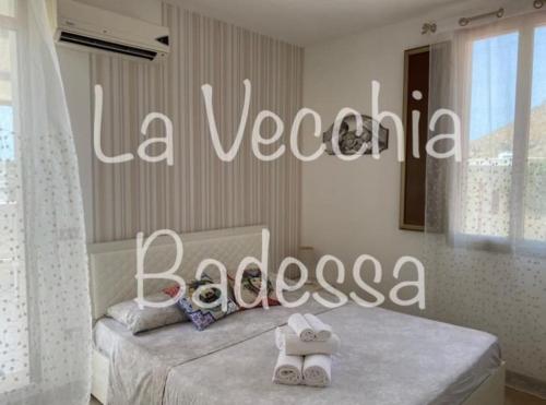 ein Schlafzimmer mit einem Bett mit einem Schild, das la veganosaosa liest in der Unterkunft La vecchia Badessa a due passi dal mare in Macari
