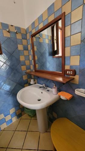 y baño con lavabo y espejo. en Mamalù en Lampedusa