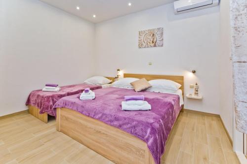 1 Schlafzimmer mit 2 Betten und lila Decken in der Unterkunft Apartments by the sea Cove Zastupac, Hvar - 8761 in Hvar