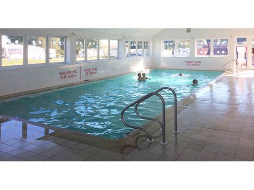 a large swimming pool with people in the water at HV66 - 3 Bedrooms Indoor Pool Loch Views Fishing Golf Riding Shooting Water Sports 15 Mins Drive To Beaches PASSES NOT INCLUDED Most Activities Will Not Be Available Out Of Season Please Check Before Booking in Newton Stewart
