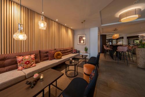a living room with a couch and tables and chairs at Hotel Ritter Durbach in Durbach