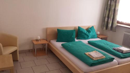 two beds in a room with green pillows on them at Gasthof Wildschönauer Bahnhof in Wörgl