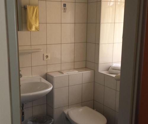 ein kleines Bad mit einem Waschbecken und einem WC in der Unterkunft Gasthof Wildschönauer Bahnhof in Wörgl