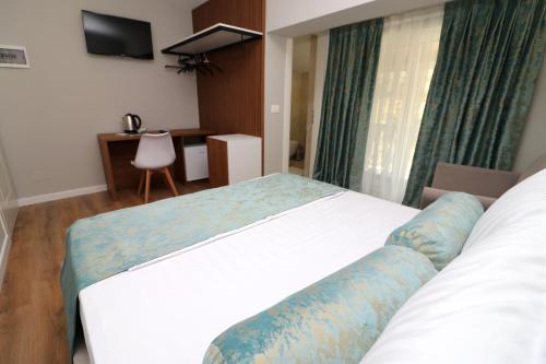 a hotel room with a bed and a desk at Vila ELARAD in Vlorë