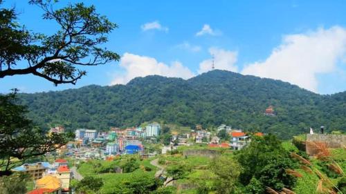uma vista para uma cidade com uma montanha ao fundo em An Phú Motel Tam Đảo em Tam Dao