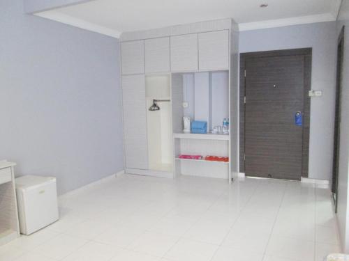 a white kitchen with a door in a room at Pelangi Hotel & Resort in Tanjung Pinang 