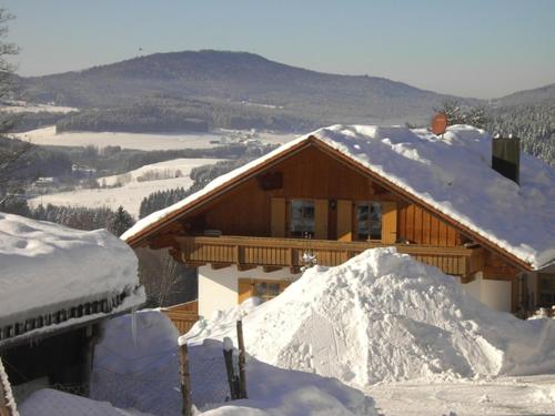 a log cabin with snow on the roof at Familienferienhof Kroner in Zwiesel