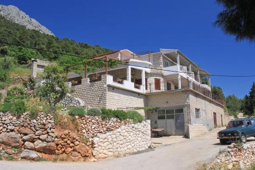 a house with a car parked in front of it at Apartments with a parking space Sveta Nedilja, Hvar - 8792 in Sveta Nedelja