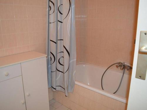 ein Badezimmer mit Duschvorhang und Badewanne in der Unterkunft Cavalaire : Appartement 2 Pièces, à 300m Plage, Clim, Balcon - FR-1-226B-331 in Cavalaire-sur-Mer