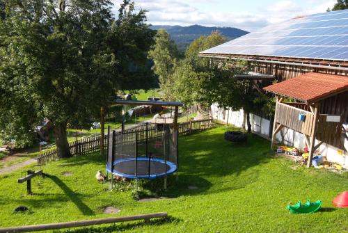 a playground in a yard next to a house at Familienferienhof Kroner in Zwiesel
