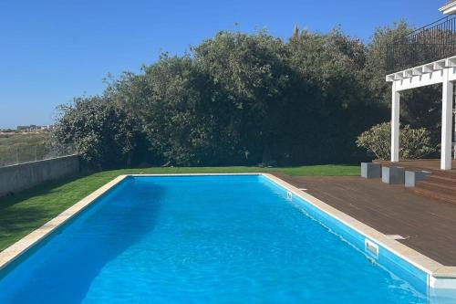 una gran piscina azul con terraza de madera en Gorgeous Mansion by Caesarea's Greatest Beach-hosted by Sweetstay, en Cesarea