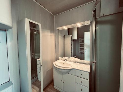 une salle de bain avec un lavabo et un miroir dans l'établissement Studio panoramique océan du Marina, à Saint-Jean-de-Monts