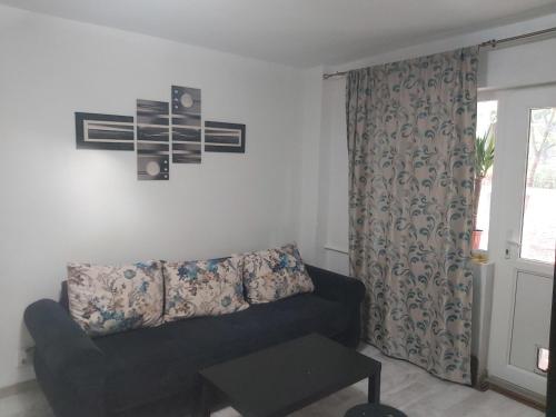- un salon avec un canapé et une fenêtre dans l'établissement Apartment Ploiesti, à Ploieşti