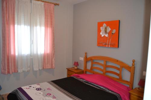 a bedroom with a bed and a flower on the wall at Apartment Deveses Park in Denia