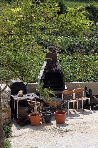 a patio with a table and chairs and a stone oven at Apartments with parking space Metajna, Pag - 527 in Metajna