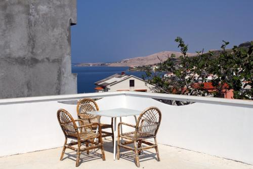 a table and chairs on a balcony with a view of the ocean at Apartments with parking space Metajna, Pag - 527 in Metajna