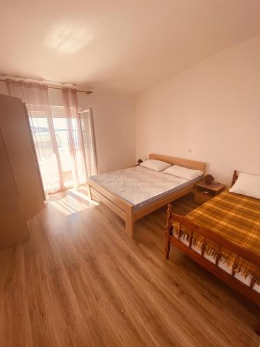 a bedroom with two beds and a large window at Apartments with parking space Metajna, Pag - 527 in Metajna