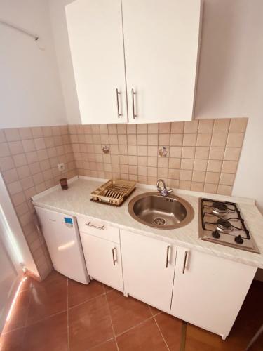 a small kitchen with a sink and a stove at Apartments with parking space Metajna, Pag - 527 in Metajna