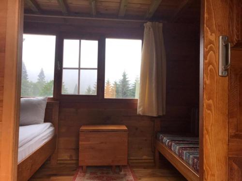 a small room with a bed and a window at Kardelen Bungalov Evleri̇ in Ayder Yaylasi